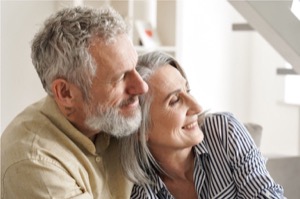 Happy older mature classy couple hugging bonding thinking of good future carefree mid age couple